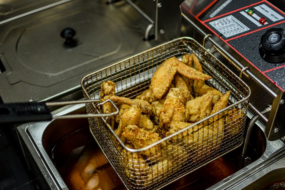 Een moderne staande friteuse met onderstel in een horecakeuken, ideaal voor efficiënt gebruik van ruimte.